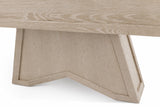 Close-up of a light oak wood table showing the underside of the tabletop and a geometric, angular pedestal base on a white background.