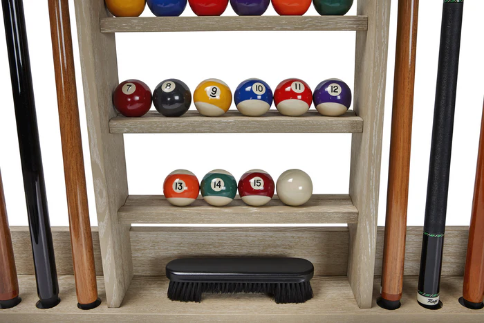 Pool balls on a wooden shelf with pool cues on either side.